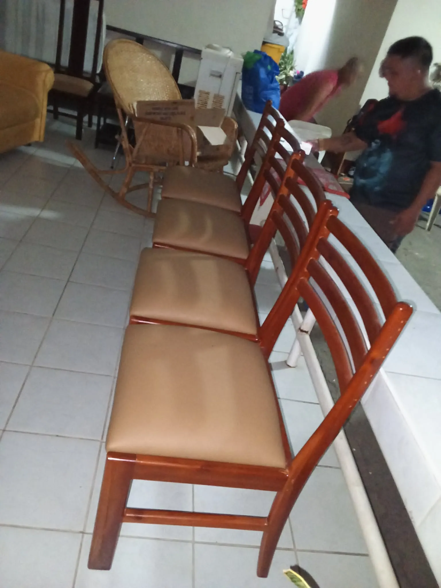 Two dark wooden dining chairs with tan upholstered seats and tall slatted backrests