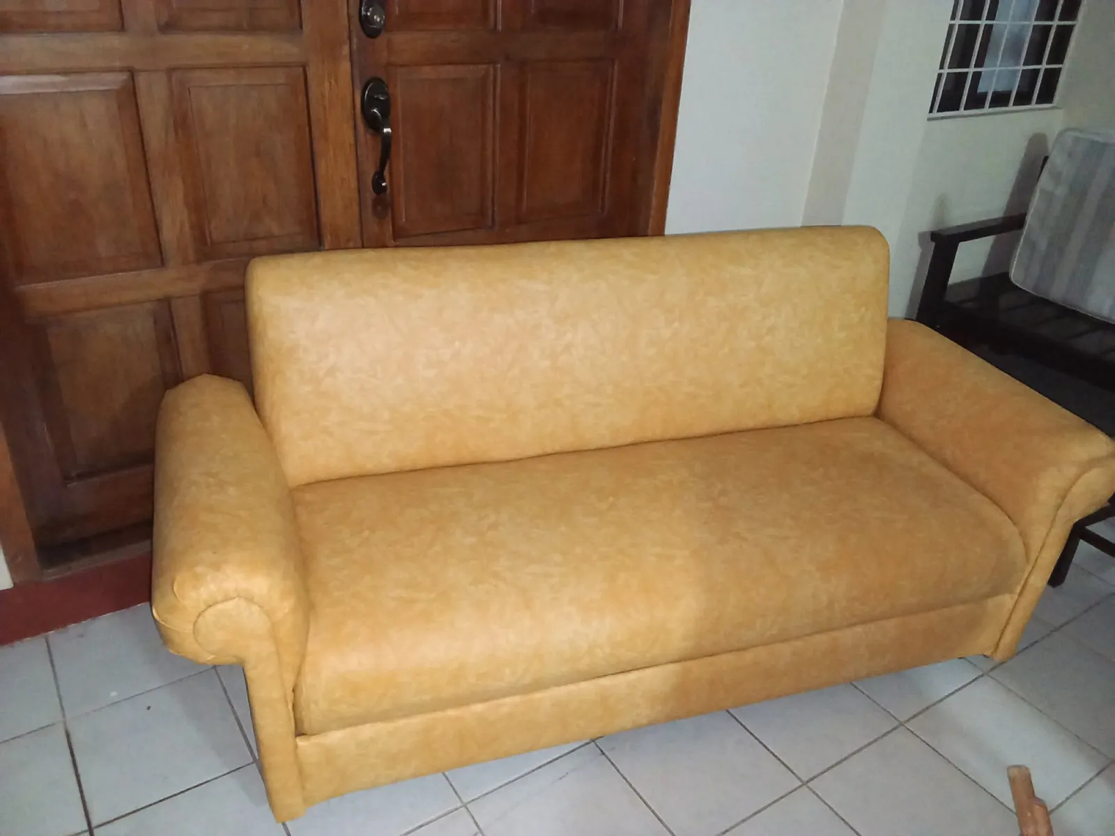 Yellow patterned sofa with rounded padded arms, a straight backrest, and a fitted upholstered base