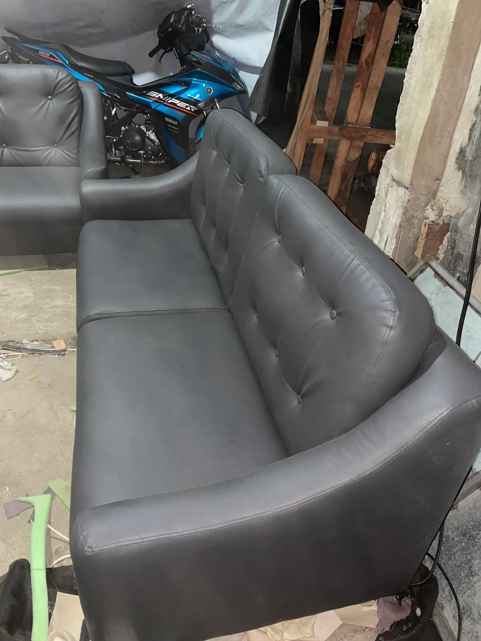     Charcoal gray button tufted sofa showing cushioned seats and backrest